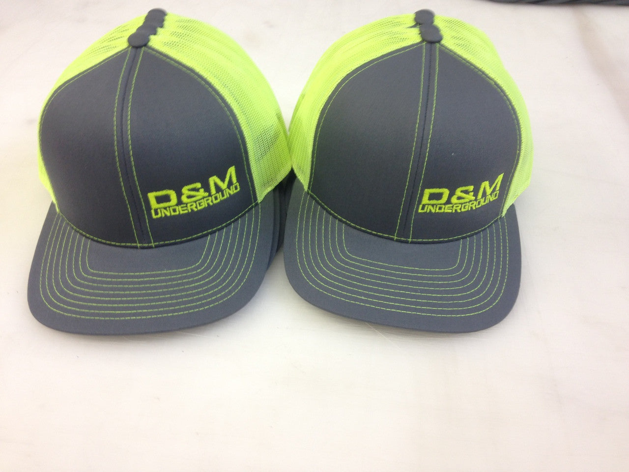 Neon yellow trucker mesh caps with left front embroidery D and M 